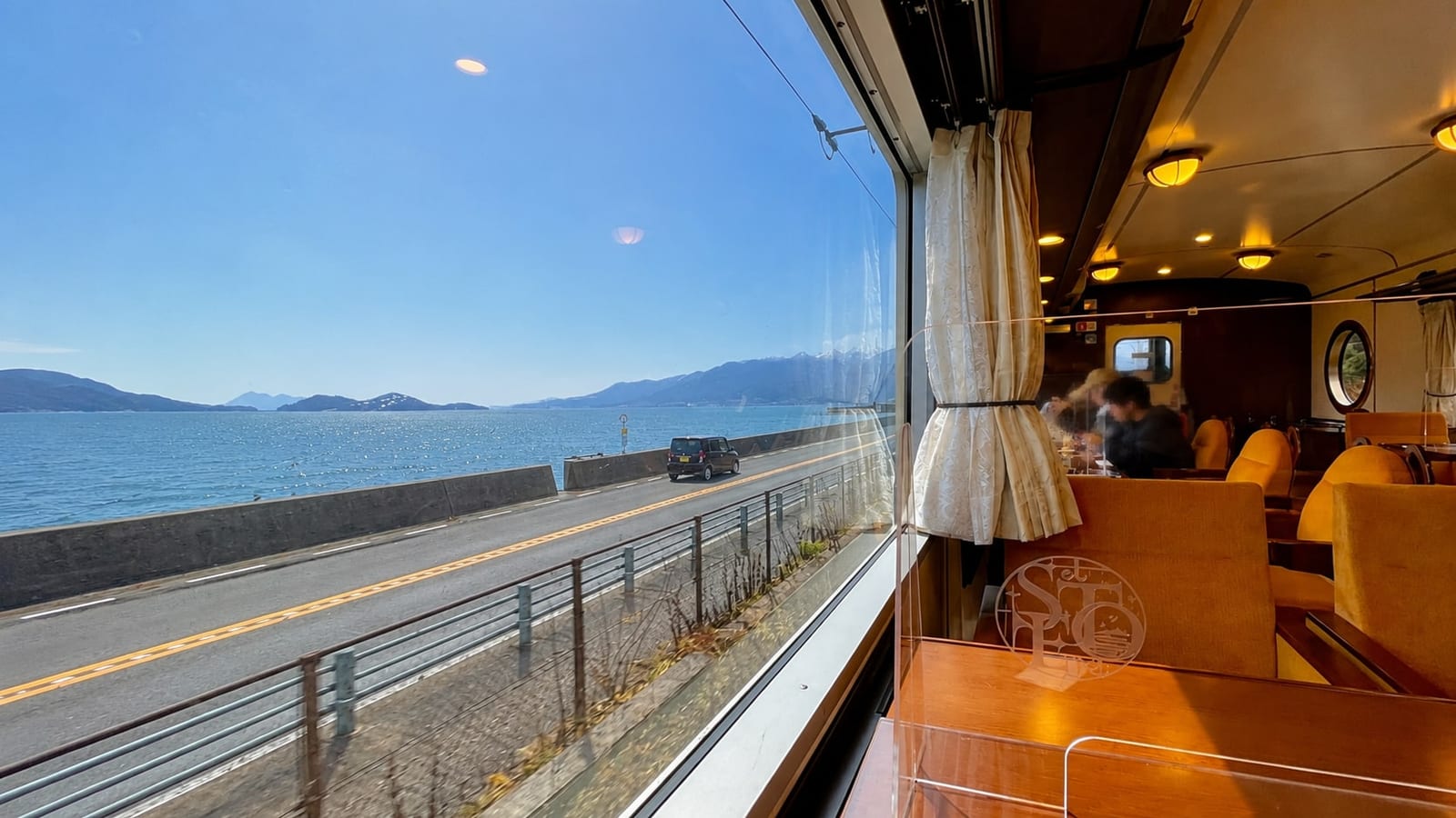 The Seto Inland Sea filling the window of a Kure Line train — this shot is from the etSETOra sightseeing train, which runs on the same tracks; ordinary trains pass the same coastline.