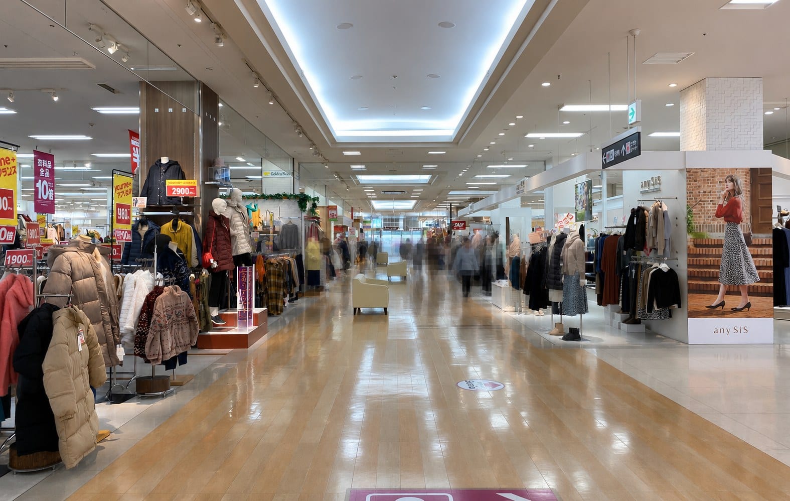 Inside the Youme Town shopping centre walkway on the route between Kure Station and the museum, a wide corridor lined with clothing stores.